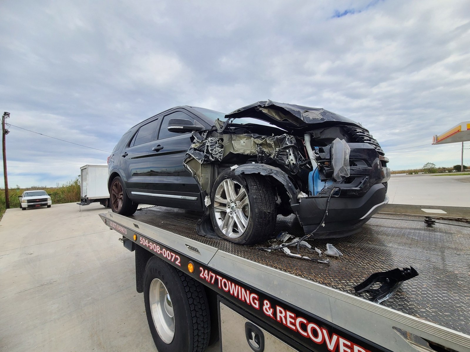 A collision-damaged SUV secured for transport